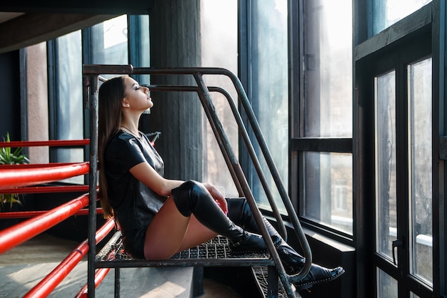 Aantrekkelijk model met lederen shorts en jas poseren op boksring.