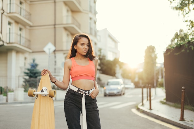 Aantrekkelijk Spaans meisje poseren met longboard