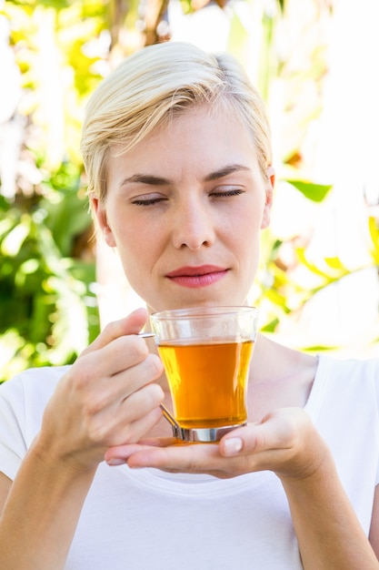 Aantrekkelijke blonde vrouw met een glas thee