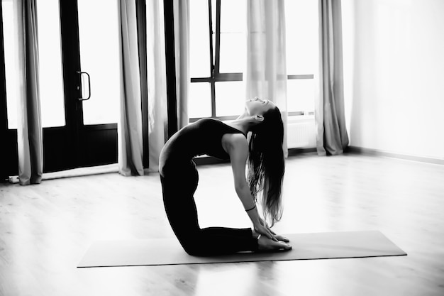Aantrekkelijke blonde vrouw met perfect lichaam in een sportkleding die in een yoga-pose staat. Concept van sport gezonde levensstijl, voeding en training training.