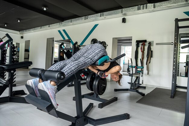 Aantrekkelijke brunette meisje doet oefeningen met een barbell in de sportschool