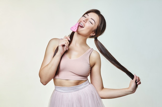 Aantrekkelijke brunette met een snoepje in de vorm van kaas