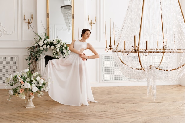 Aantrekkelijke danseres in een prachtige klassieke witte zaal