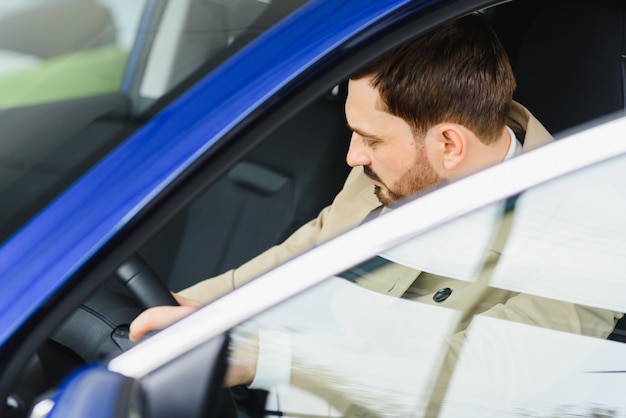 Aantrekkelijke elegante gelukkig man in goede auto