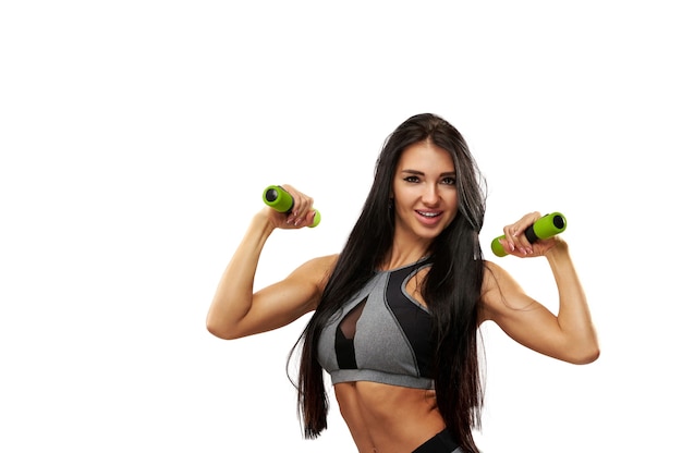 Aantrekkelijke fitness vrouw uit te werken met halters. Portret geïsoleerd op een witte achtergrond.