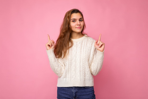 Aantrekkelijke gelukkige jonge donkerblonde krullende vrouw in casual witte trui sexy zorgeloze vrouwelijke persoon