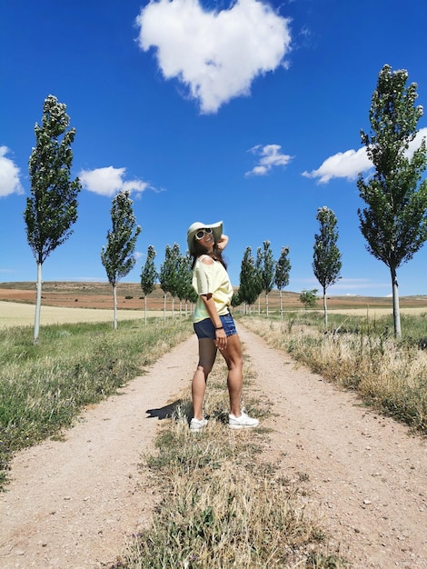 Aantrekkelijke gelukkige vrouw van middelbare leeftijd in een hoed die van het platteland en de vakantie geniet