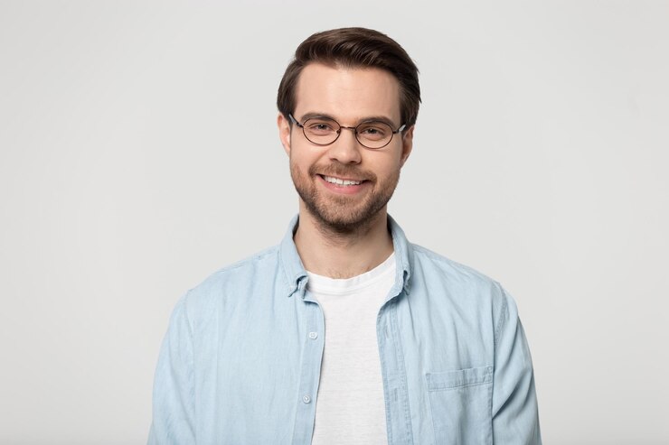 Foto aantrekkelijke glimlachende jonge man in een bril studio headshot