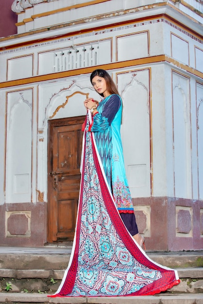 Aantrekkelijke hete meid op de rug met een Desi-jurk voor een modefotoshoot op een oude plek