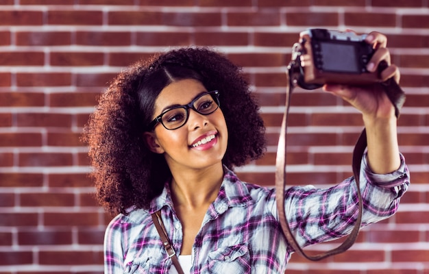 Aantrekkelijke hipster die selfies met camera neemt