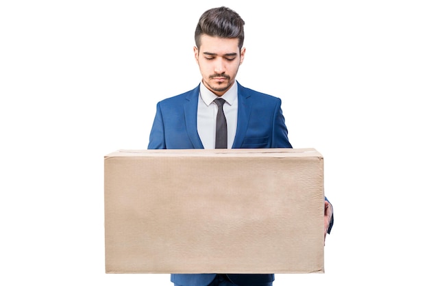 Aantrekkelijke jonge man in een blauw pak met een kartonnen doos in zijn handen geïsoleerd