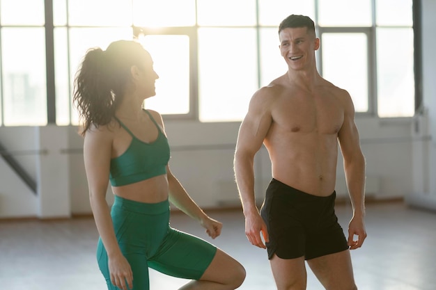 Aantrekkelijke jonge Spaanse jongen en meisje praten tijdens het trainen in de sportschool Training in sporthal