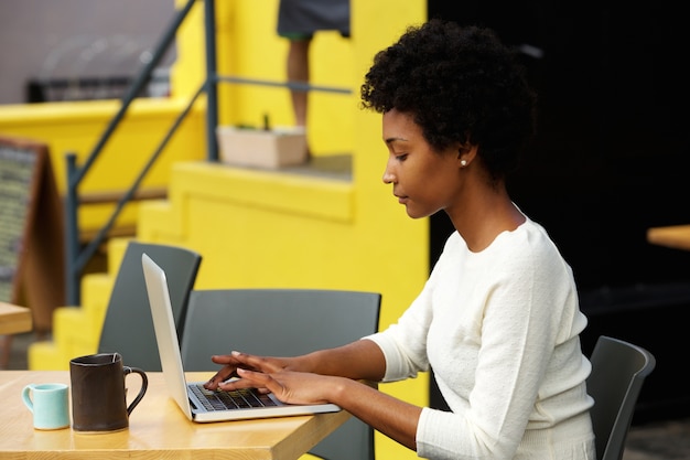 Aantrekkelijke jonge vrouw die laptop buiten met behulp van