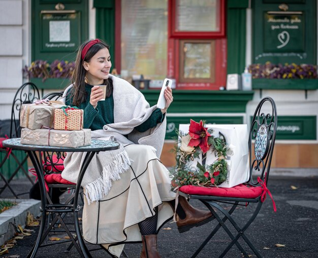 Aantrekkelijke jonge vrouw gebruikt smartphone kerst online winkelen