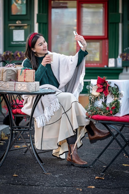 Aantrekkelijke jonge vrouw gebruikt smartphone kerst online winkelen