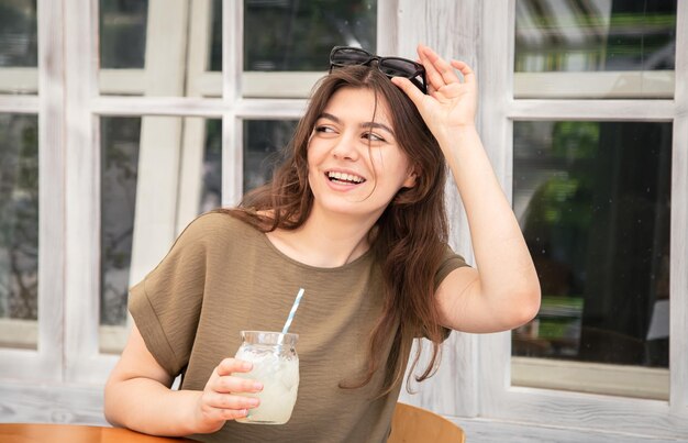 Aantrekkelijke jonge vrouw met een glas limonade op een warme zomerdag