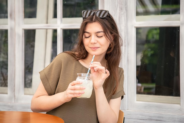 Aantrekkelijke jonge vrouw met een glas limonade op een warme zomerdag