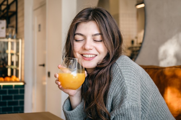 Aantrekkelijke jonge vrouw met een glas vers geperst sinaasappelsap