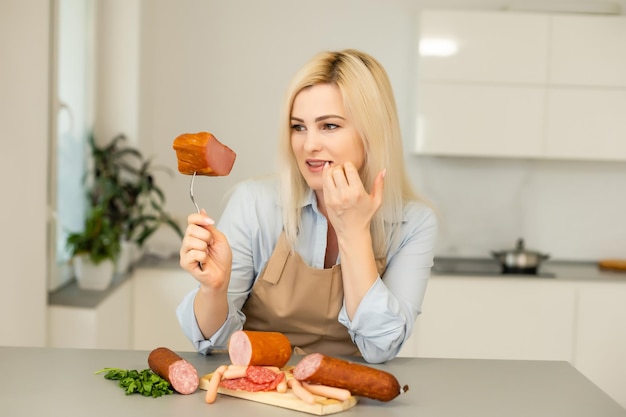 Aantrekkelijke jonge vrouw met een worst op een vork