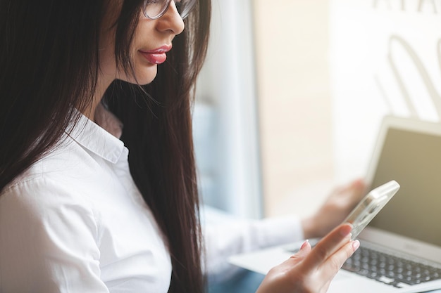 Aantrekkelijke jonge vrouw met laptop Vrouw in cafetaria met gadgets Busuness vrouw binnenshuis