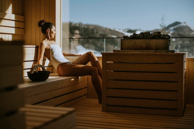 Aantrekkelijke jonge vrouw ontspannen in de sauna