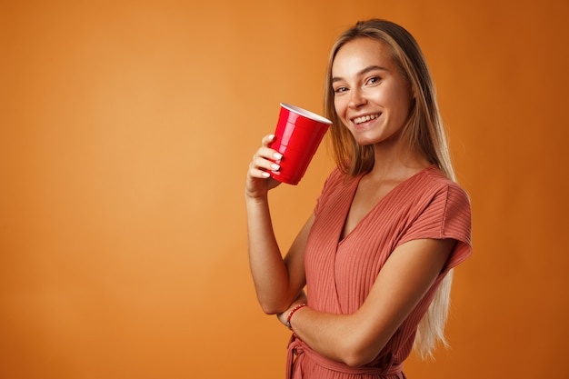 Aantrekkelijke jonge vrouw permanent en warme drank drinken