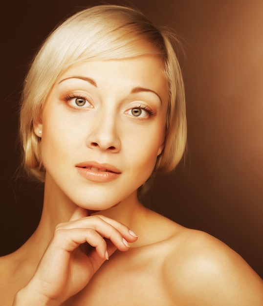 Foto aantrekkelijke jonge vrouwen met gouden haar over beige muur