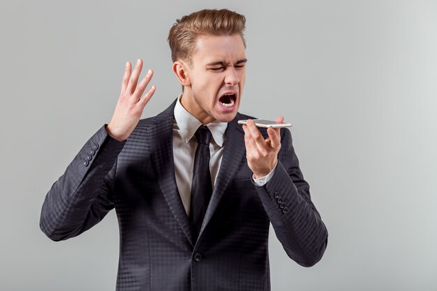 Aantrekkelijke jonge zakenman die op de telefoon spreekt.