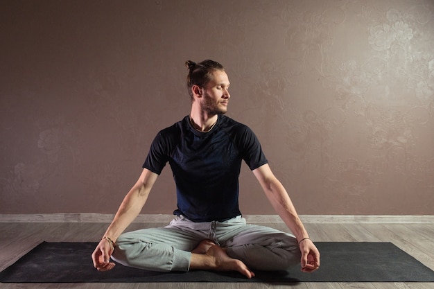 Aantrekkelijke jongeman beoefenen van yoga sportkleding dragen