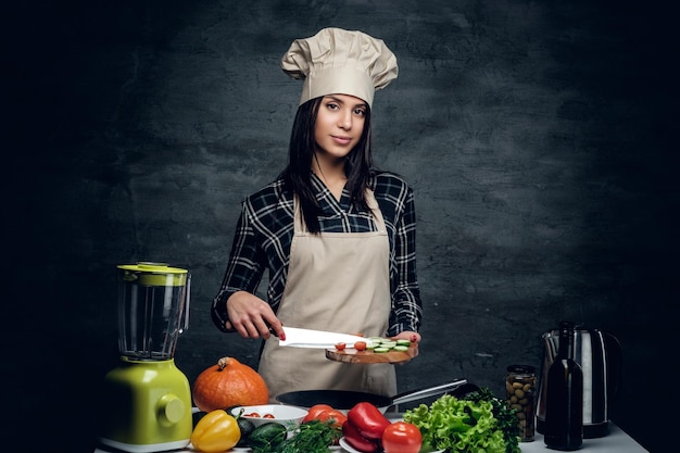 Aantrekkelijke kok vrouwelijke snijden groenten voor een gezonde salade.