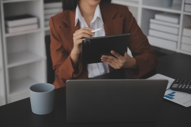 Aantrekkelijke lachende jonge Aziatische zakenvrouw werk thuis kantoor Aziatische vrouw die werkt op laptop computer bedrijf tablet