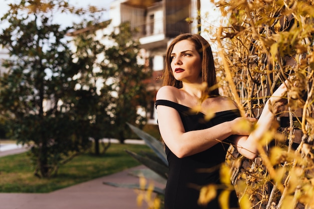 Aantrekkelijke luxe vrouw wandelen in de tuin en poseren, genietend van een rijk leven