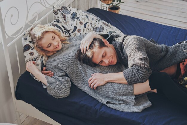 Aantrekkelijke man en vrouw in de slaapkamer samen schattig knuffelen