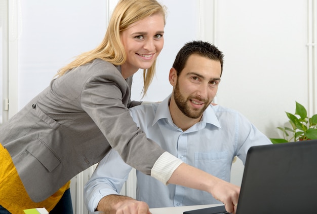Aantrekkelijke man en vrouwenzaken die laptop computer met behulp van