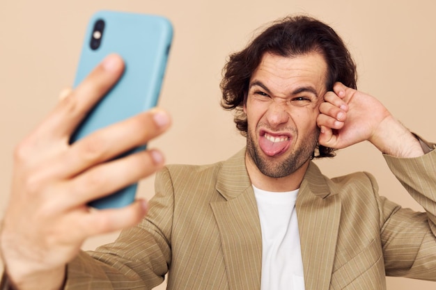 Aantrekkelijke man in een pak poseren emoties kijken naar de telefoon geïsoleerde achtergrond