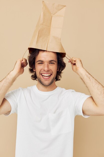 Aantrekkelijke man in een wit t-shirt met een ongewijzigde levensstijl van een papieren zak