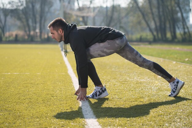 Aantrekkelijke man klaar voor de race in stadspark gebied opleiding en oefenen voor uithoudingsvermogen Fitness gezonde levensstijl Concept buiten