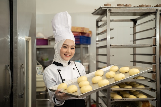Aantrekkelijke moslimvrouw chef-kok beroep dienblad glimlachen naar camera dragen hijab