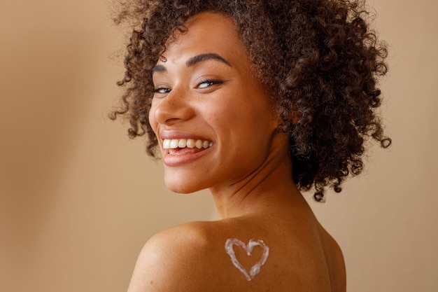 Foto aantrekkelijke multiraciale vrouw poseren op camera over beige achtergrond