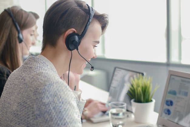 Aantrekkelijke positieve jonge ondernemers en collega's in een callcenterkantoor.