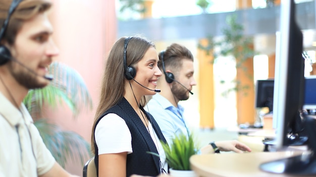 Aantrekkelijke positieve jonge ondernemers en collega's in een callcenterkantoor