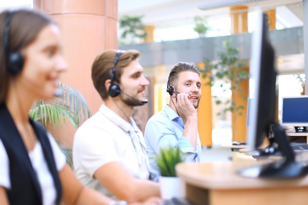 Aantrekkelijke positieve jonge ondernemers en collega's in een callcenterkantoor.