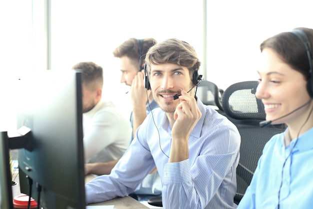 Aantrekkelijke positieve jonge ondernemers en collega's in een callcenterkantoor.