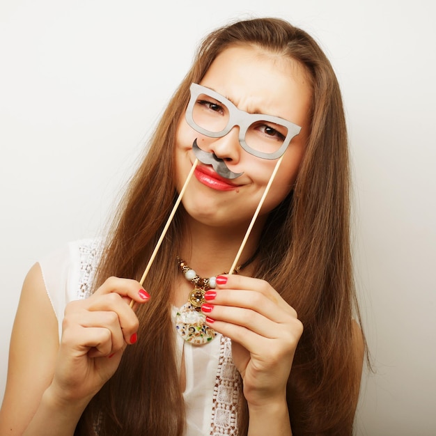 Aantrekkelijke speelse jonge vrouw met snor en bril op een stokje Klaar voor feest