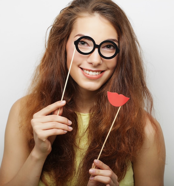 Aantrekkelijke speelse jonge vrouw met valse bril, klaar voor feest