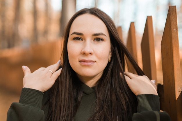 Aantrekkelijke stijlvolle vrouw loopt in het park gekleed in een warme hoodie mooi meisje glimlacht herfst stedelijke