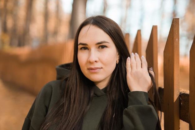 Aantrekkelijke stijlvolle vrouw loopt in het park gekleed in een warme hoodie mooi meisje glimlacht herfst stedelijke