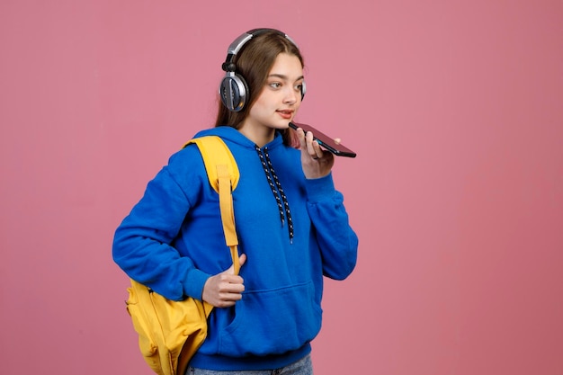 Aantrekkelijke tienermeisje in casual outfit met behulp van luidspreker om te praten via de mobiele telefoon