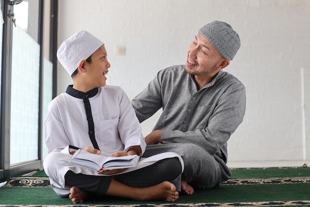 Aantrekkelijke vader en zoon hebben hechtingsmomenten terwijl ze koran onderwijzen en leren in de moskee