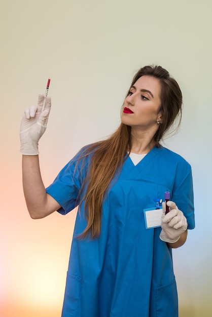 Aantrekkelijke verpleegster met spuit klaar voor injectie. Medisch thema
